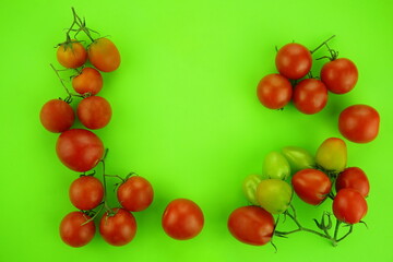 Small cherry tomatoes on a green background. Food concept, flat lay, copy space.

