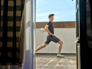Teenage boy exercising on the terrace at home during lockdown