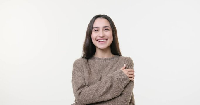 Cheerful woman laughing with arms crossed over white background