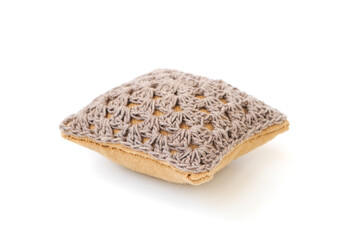 Needle cushion in the form of a handmade pillow isolated on white background .