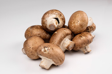 Pilze: Eine Handvoll natürliche braune Champignongs auf einem weißen Hintergrund (lat.: Agaricus bisporus)