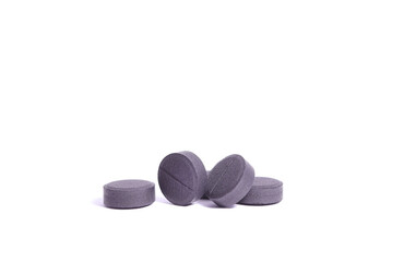 Activated charcoal (medication). Absorbent carbon or activated carbon in tablets isolated on white. Medication used to treat poisonings that occurred by mouth.