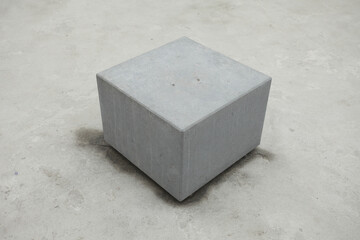 Urban architecture concept. Gray cube with cement on concrete background. Copy-space. Outdoor shot