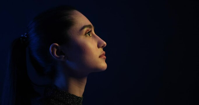 Side view of thoughtful woman on black background
