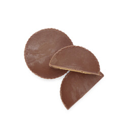 Cut and whole delicious peanut butter cups on white background, top view