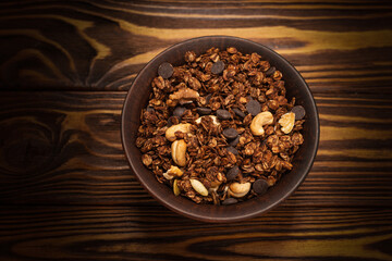 Chocolate granola cereal with nuts in a bowl.