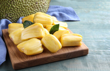 Fresh exotic jackfruit bulbs on light blue wooden table