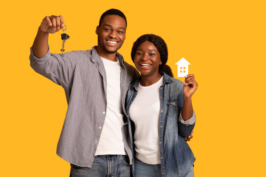 New Home Owners. Happy African American Couple Holding Paper House And Keys