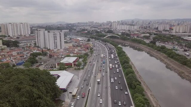 Aerial drone view of the Marginal Tiet&ecirc; Avenue car traffic, Tiete River and beautiful S&atilde;o Paulo city skyline on cloudy day. Concept of urban landscape, travel, cityscape, co2, pollution, metropolis.