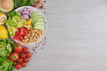 Healthy vegan lunch bowl, buddha bowl salad with ingredients. chickpeas and mixed Vegetables, radish, avocado, tomato, lemon . Healthy balanced vegetarian food concept. Top view.