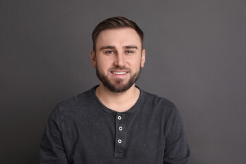Obraz premium Portrait of happy young man on grey background. Personality concept