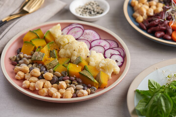 Healthy vegan lunch bowl, buddha bowl salad. chickpeas, radish, pumpkin with cauliflower  and vegetables. Healthy balanced vegetarian food concept.