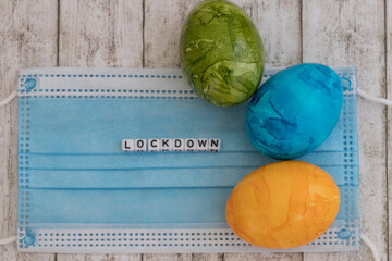 Easter eggs and surgical mask with the word lockdown as a concept for the decision of the german...