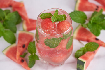 Homemade watermelon lemonade, portrait of summer fresh fruit drink. fruit flavored water mix with lemon, watermelon, mint leaves and ice. detox water cocktail, selective focus.