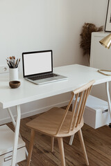 Laptop computer with blank screen on table. Aesthetic minimal office workspace interior design template with mockup copy space.