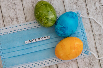 Easter eggs and surgical mask with the word lockdown as a concept for the decision of the german...