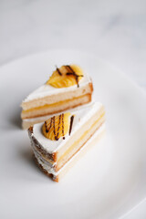 cake on a dessert plate. brownie with white cream on a dark background. cake close-up. cut cake.