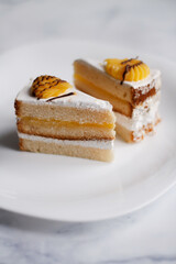 cake on a dessert plate. brownie with white cream on a dark background. cake close-up. cut cake.