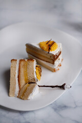 cake on a dessert plate. brownie with white cream on a dark background. cake close-up. cut cake.
