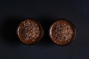 Homemade dark chocolate mousse in glasses on dark grey table