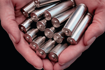 Hands holding alkaline batteries, closeup. Recycling, energy and power supply concept