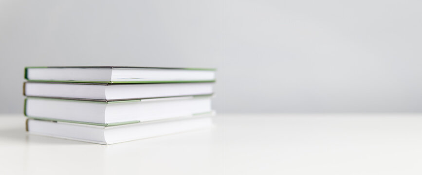 Stack of books on a white background. The book lies on a plain background with space for writing. Composition of a reading person.