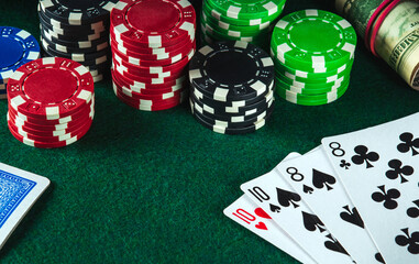 Poker cards with the two pairs combination in casino. Chips and money on the green table