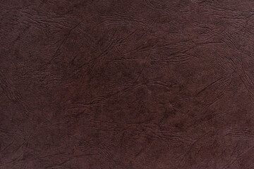 Abstract dark brown paper texture with leather-like embossing.