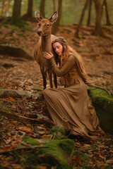 Redhead girl with deer in a long dress