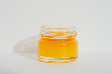 Yellow golden honey in glass jar, closeup. Atmospheric minimalistic apiculture concept