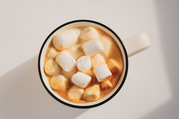 Morning coffee cup with marshmallow. Closeup, top view. Sunny atmospheric minimalistic concept