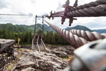 Obraz premium Close-up on a metal binding cable going in perspective to the bridge support with the texture of a summer sunny day. Reliability and strength concept, architecture.