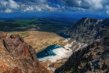 View of a mountain lake at the foot of a mountain with snow in the Altai mountains Sarlyk