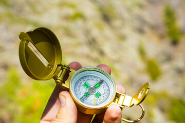 Man explorer searching direction with compass in summer mountains, point of view. © Maxim Chuev