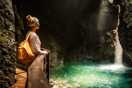 Woman standing at the edge and looking at wonderful scenery. Kozjak waterfall one of the beautiful waterfall in Slovenia. Popular place to vitis near river soca, kobarid.