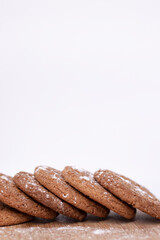 oatmeal cookies covered in powdered sugar on wooden stand board. sweet bakery concept