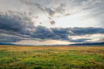 Fields and open spaces in the steppes of Tuva against the background of sunset clouds in autumn it is time to harvest cereals