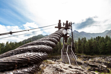Close-up on a metal binding cable going in perspective to the bridge support with the texture of a...