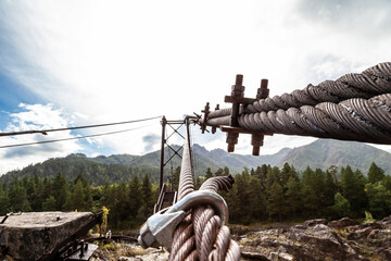 Close-up on a metal binding cable going in perspective to the bridge support with the texture of a...