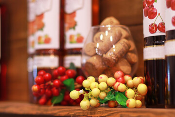 Decorative berries and fruits bottles of drinks and alcohol on a wooden shelf blurred background