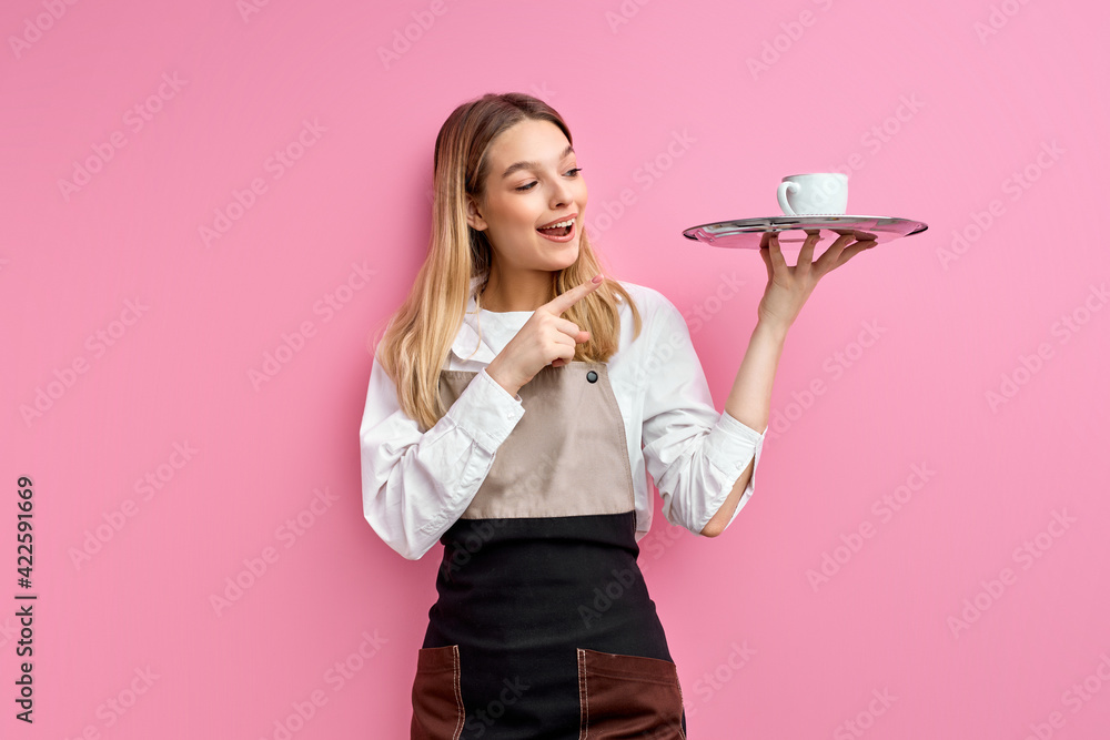 Wall mural attractive caucasian waitress woman in apron holding tray with cup, index finger