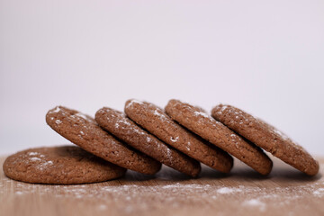 oatmeal cookies covered in powdered sugar on wooden stand board. sweet bakery concept