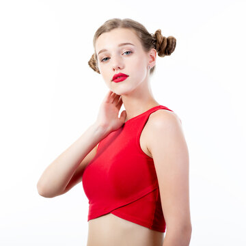 Young charming woman wearing red top posing at studio over white background