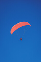 Parapente biplace en vol dans un ciel tout bleu