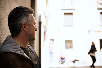 Fototapeta premium Urban outdoor portrait of a handsome man wearing brown jacket, street style at spring