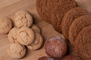 muffins, almond amaretti and oat cookies on wooden stand board. sweet bakery concept