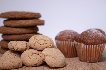 muffins, almond amaretti and oat cookies on wooden stand board. sweet bakery concept