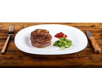 Meat with herbs and ketchup on a white plate. Board. White background.