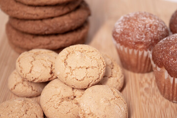 muffins, almond amaretti and oat cookies on wooden stand board. sweet bakery concept