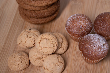 muffins, almond amaretti and oat cookies on wooden stand board. sweet bakery concept